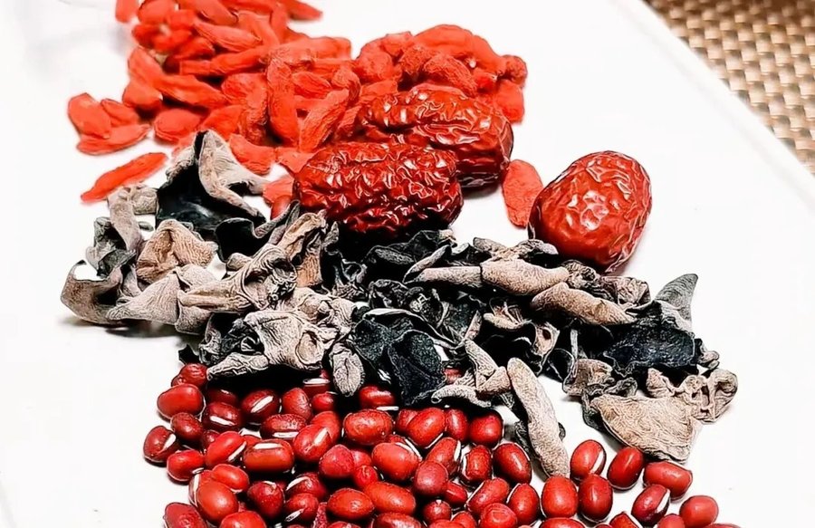 Black fungus, red dates, goji berries, and red beans laid out on a plate before soaking